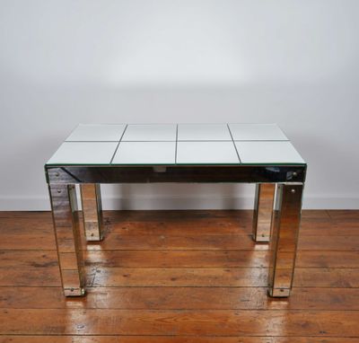 a glass and chrome coffee table on a wooden floor