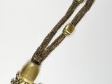 an image of a necklace with a bell hanging from it ' s end