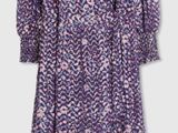 purple and white dress on a hanger against a white wall