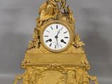 a gold clock with a statue on top of it