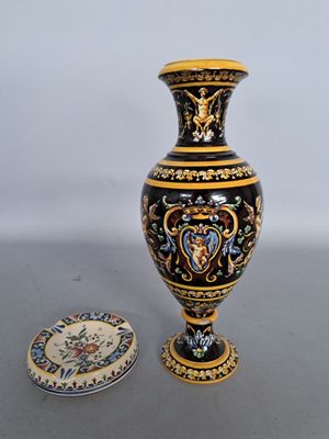 a black and gold vase next to a plate on a table
