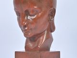 sculpture of a woman ' s head on a wooden base