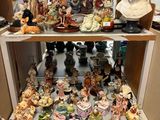 de nombreuses figurines posées sur une étagère dans une pièce