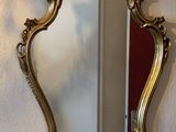 un miroir accroché au mur à côté d'une lampe