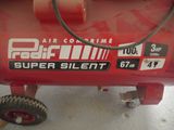 a red air compressor sitting on top of a table