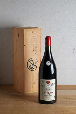 une bouteille de vin posée à côté d'une caisse en bois