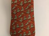 une cravate orange ornée d'un motif paisley vert