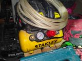 a yellow compressor sitting on top of a pile of assorted items