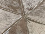 a close up of a cow hide rug with a wooden floor