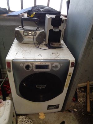 une machine à laver blanche posée sur un sèche-linge