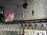 many wine glasses hanging from the ceiling above the bar