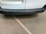 the rear end of a white van parked in a parking lot