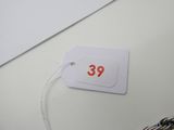 une étiquette blanche portant un chiffre rouge, posée sur une table