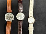 three different types of watches on a black surface
