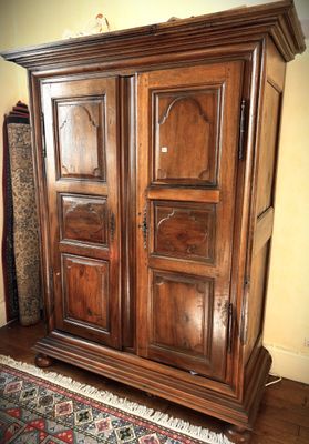 a large wooden armoire in the corner of a room