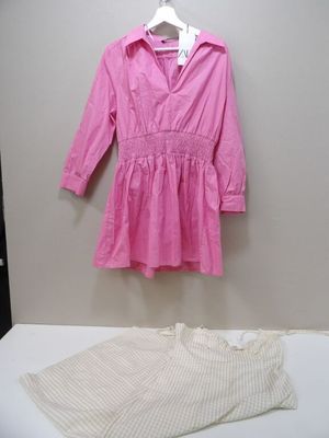 a pink shirt and white pants on a white table