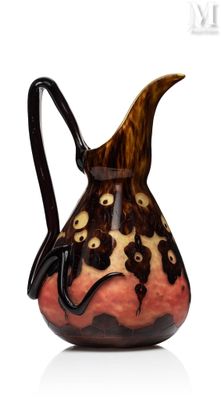 un vase marron et noir, muni d'une anse noire sur un fond blanc