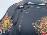 a black plate with a gold and red design on it