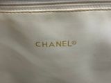 a close up of a white bag with a gold logo on it