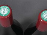 two bottles of wine sitting next to each other on a table