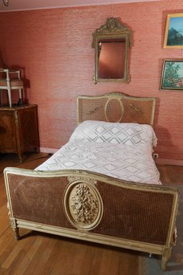 un lit dans une chambre où il y a un miroir accroché au mur