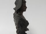 a close up of a statue of a woman wearing a hat