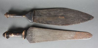 deux vieux couteaux posés l'un à côté de l'autre sur une table