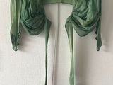 une chemise verte accrochée au mur à côté d'un cintre