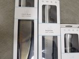 three boxes of kitchen knives sitting next to each other on a table