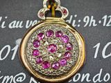 un gros plan sur une boucle d'oreille en or ornée de pierres roses