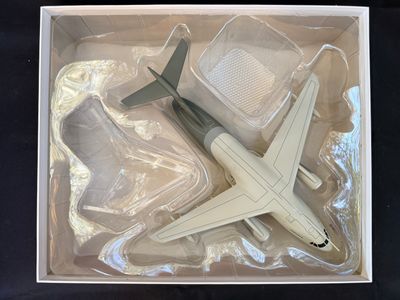 un petit avion en jouet dans une boîte posée sur une table