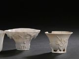 three white vases sitting next to each other on top of a table