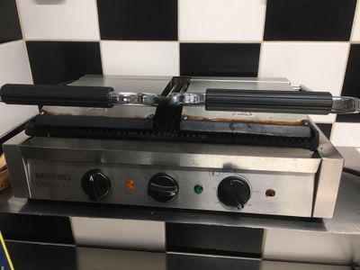 un plan de travail à carreaux noirs et blancs surmonté d'un grill