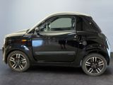 a black smart car parked on a gray floor