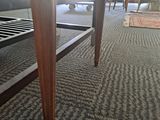 a table that has a bench underneath it on the carpet