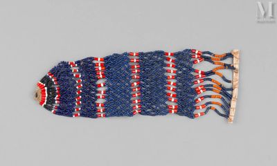 un gros plan sur un bracelet bleu et rouge orné de franges