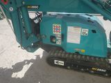 a small blue excavator that is parked on the side of the road