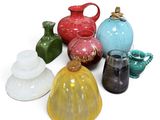 many different colored vases on a white surface