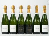 six bouteilles de vin sont alignées sur une table