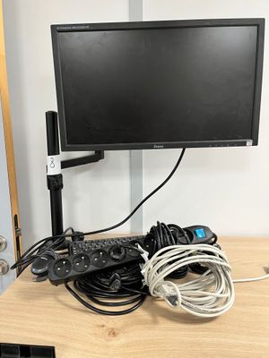 un écran d'ordinateur posé sur un bureau en bois