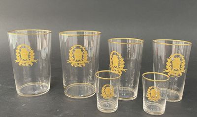 six verres ornés de motifs dorés, posés sur une table