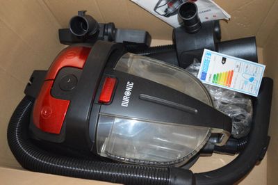un aspirateur rouge et noir rangé dans une boîte