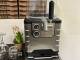 a coffee machine sitting on a table in front of a pizza box