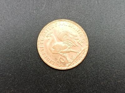 a close up of a gold coin on a black surface