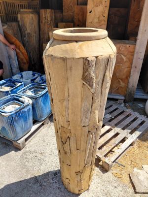 a large vase made out of wood sitting on a pallet
