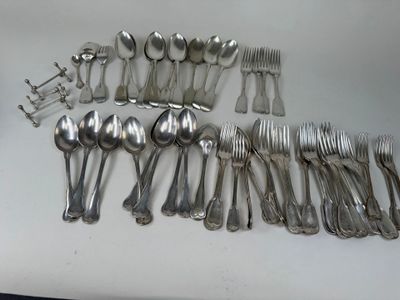 many spoons and forks laid out on a table