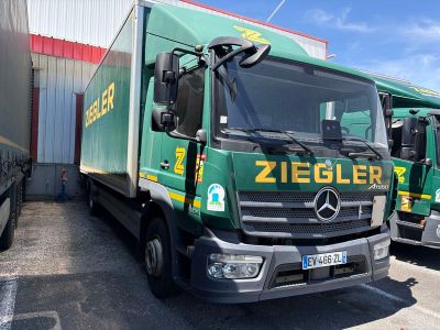 deux camions verts garés l'un à côté de l'autre sur un parking