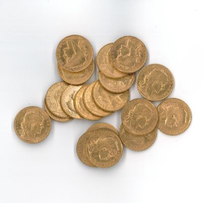 une pile de pièces d'or posée sur une surface blanche