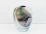 a glass vase that has a green and black design on it
