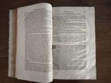 an open book on a wooden table with a pen in it